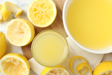 Photo of Fresh lemon juice and squeezed fruits on table, flat lay