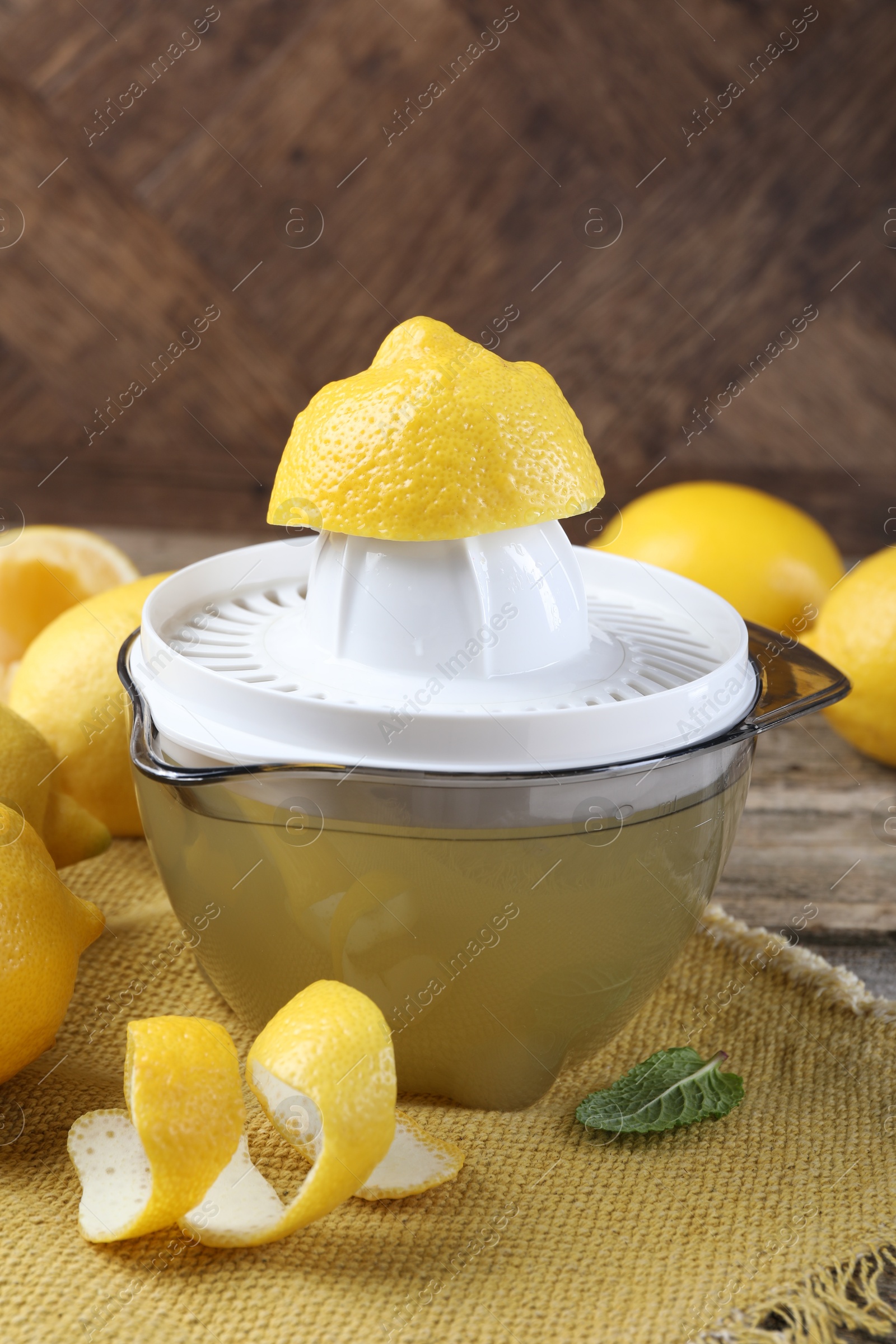 Photo of Juicer and fresh lemons on wooden table