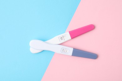 Photo of Two pregnancy tests on color background, top view