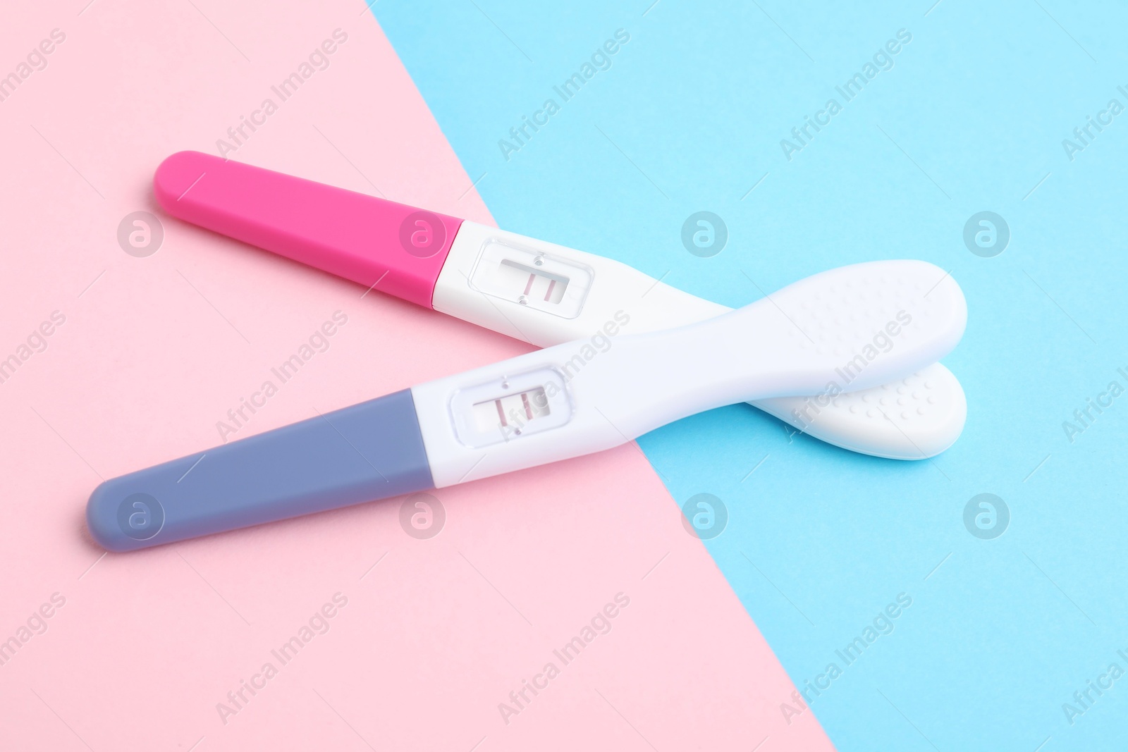 Photo of Two pregnancy tests on color background, above view