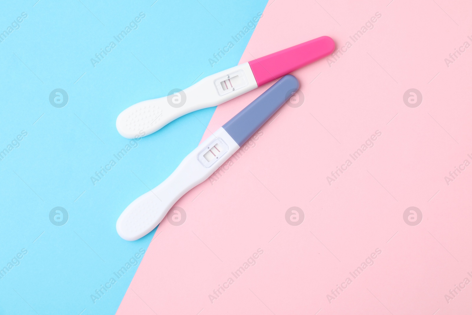 Photo of Two pregnancy tests on color background, top view. Space for text