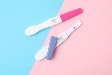 Photo of Two pregnancy tests on color background, top view