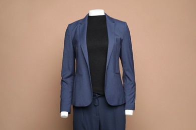 Photo of Female mannequin with stylish suit on light brown background