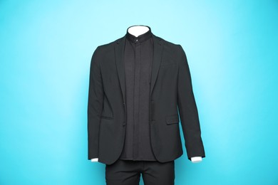 Photo of Male mannequin with stylish black suit on light blue background