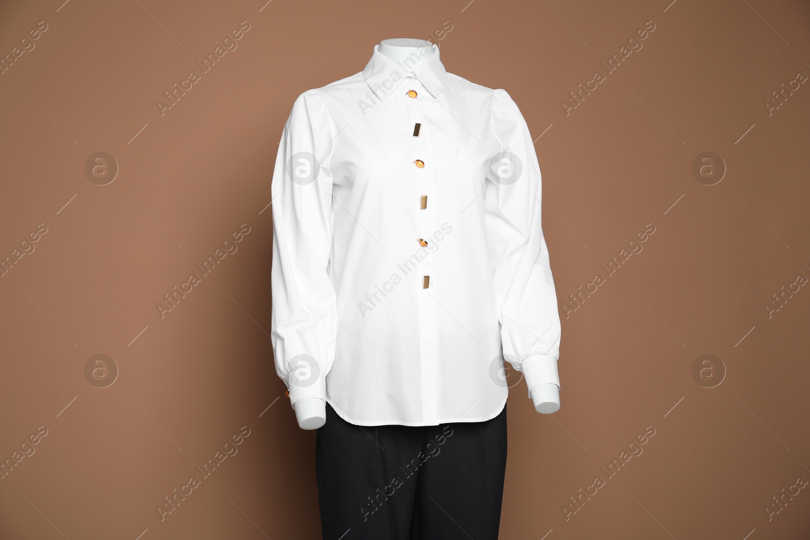 Photo of Female mannequin with stylish shirt and pants on light brown background