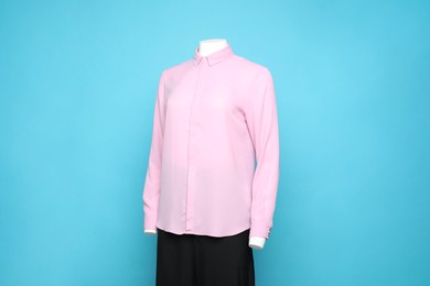 Photo of Female mannequin with stylish shirt and pants on light blue background