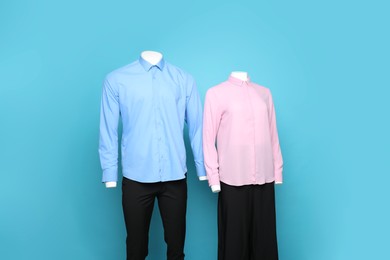 Photo of Female and male mannequins with stylish outfits on light blue background