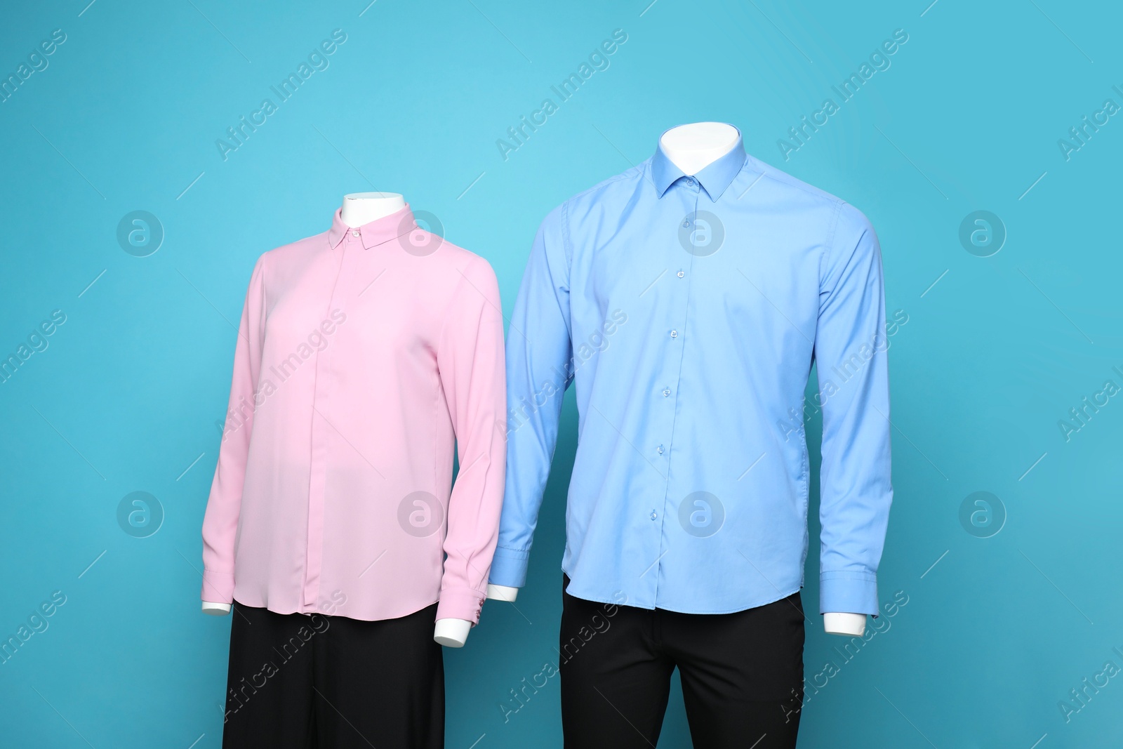 Photo of Female and male mannequins with stylish outfits on light blue background