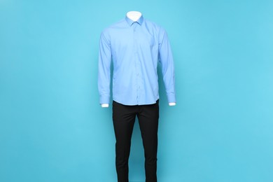 Photo of Male mannequin with stylish shirt and pants on light blue background