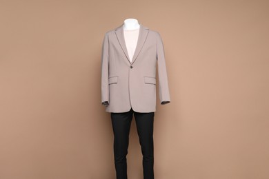 Photo of Male mannequin with stylish outfit on light brown background, space for text