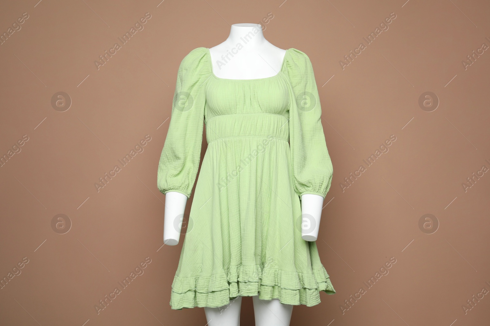 Photo of Female mannequin with stylish dress on light brown background