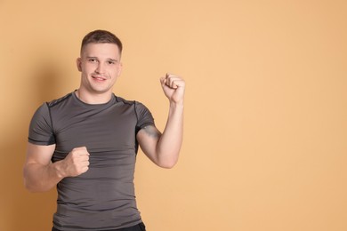 Photo of Portrait of happy winner on beige background, space for text