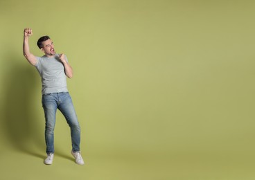 Photo of Portrait of happy winner on pale olive background