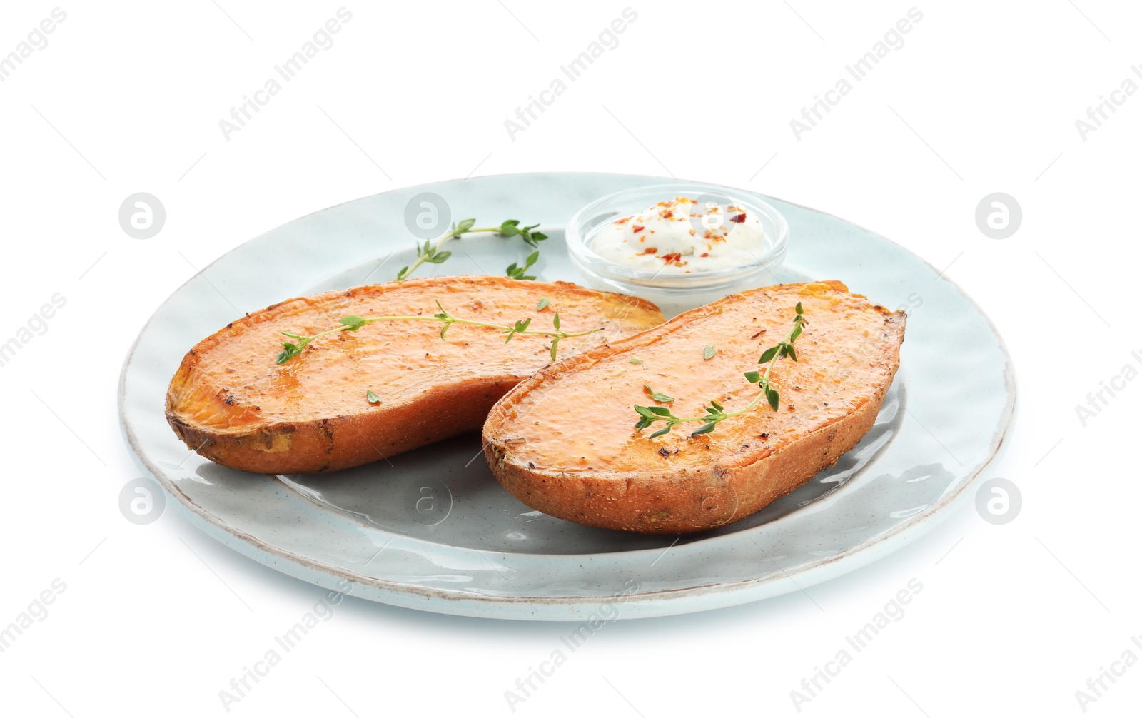 Photo of Halves of tasty cooked sweet potato with thyme and sauce isolated on white