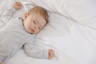 Cute little baby sleeping on bed at home, space for text