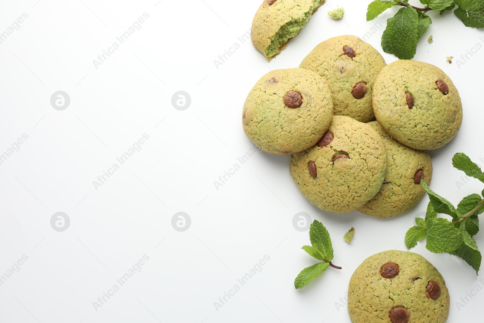 Photo of Delicious chocolate chip cookies and mint leaves on white table, flat lay. Space for text