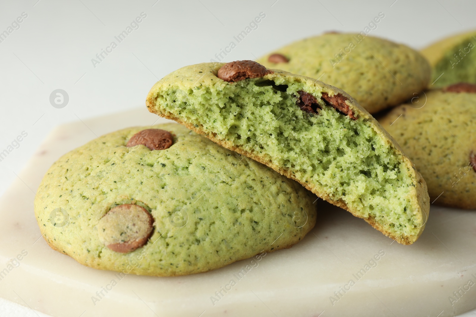 Photo of Delicious mint chocolate chip cookies on white table, closeup