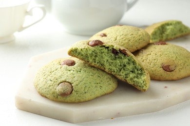 Photo of Delicious mint chocolate chip cookies on white table, closeup