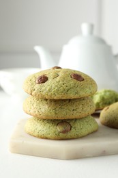 Photo of Delicious mint chocolate chip cookies on white table, closeup