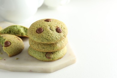 Photo of Delicious mint chocolate chip cookies on white table, closeup. Space for text