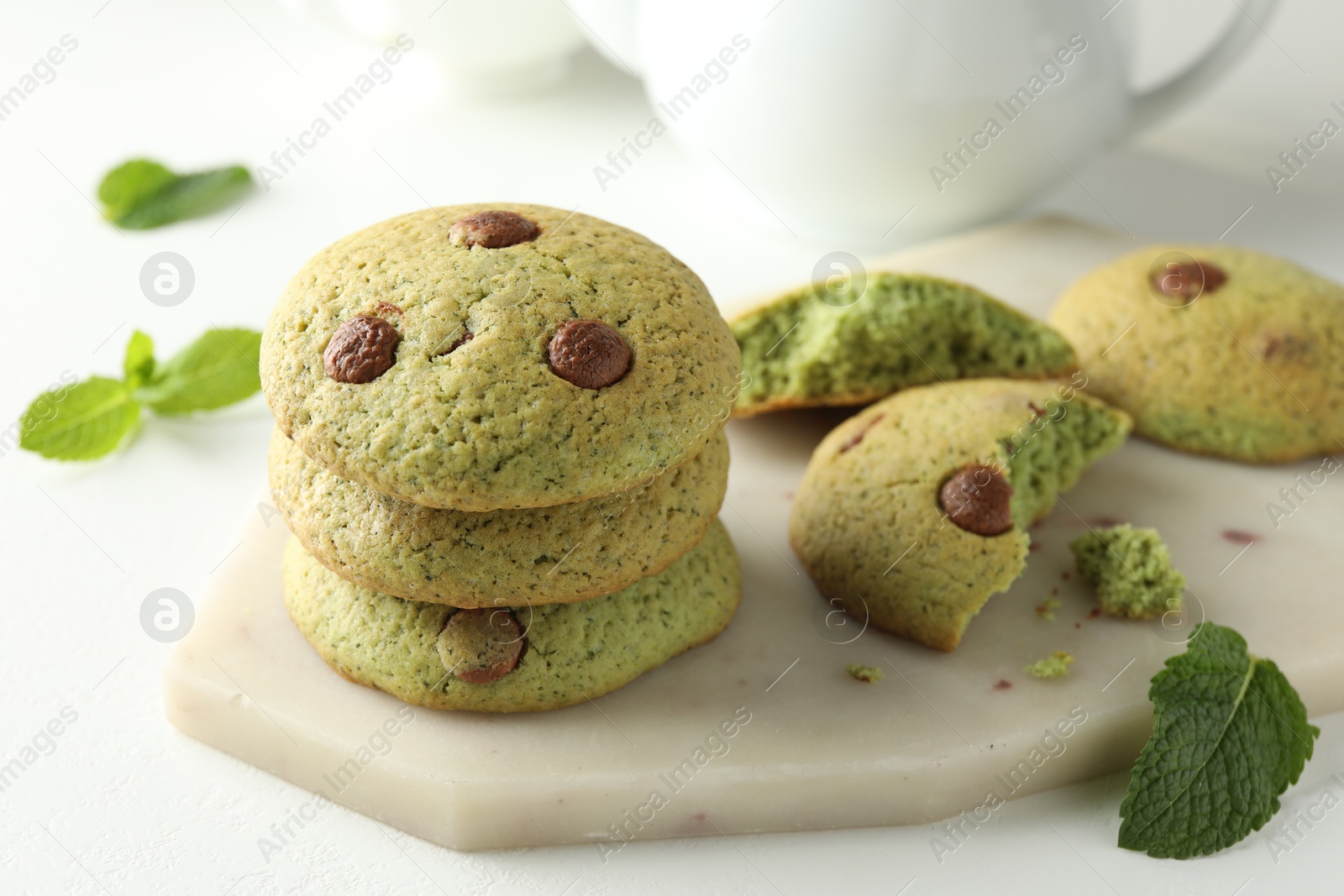 Photo of Delicious mint chocolate chip cookies on white table, closeup