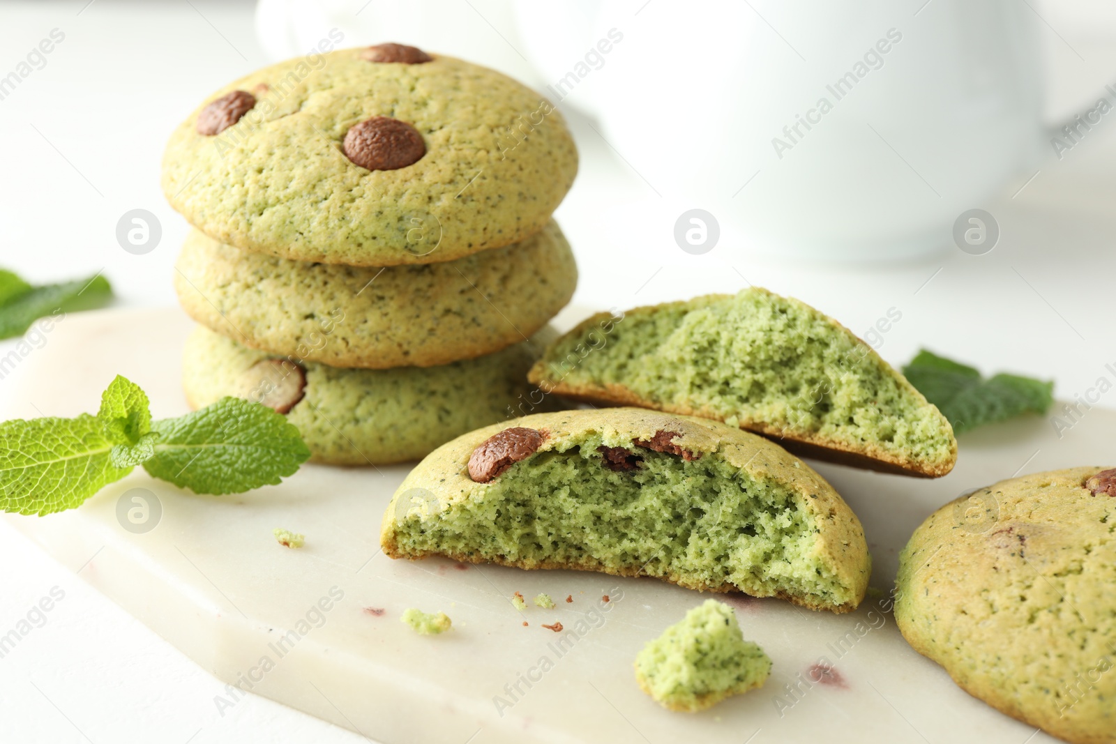 Photo of Delicious mint chocolate chip cookies on white table, closeup