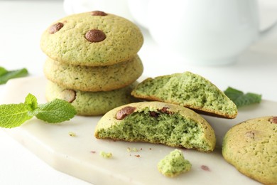 Photo of Delicious mint chocolate chip cookies on white table, closeup