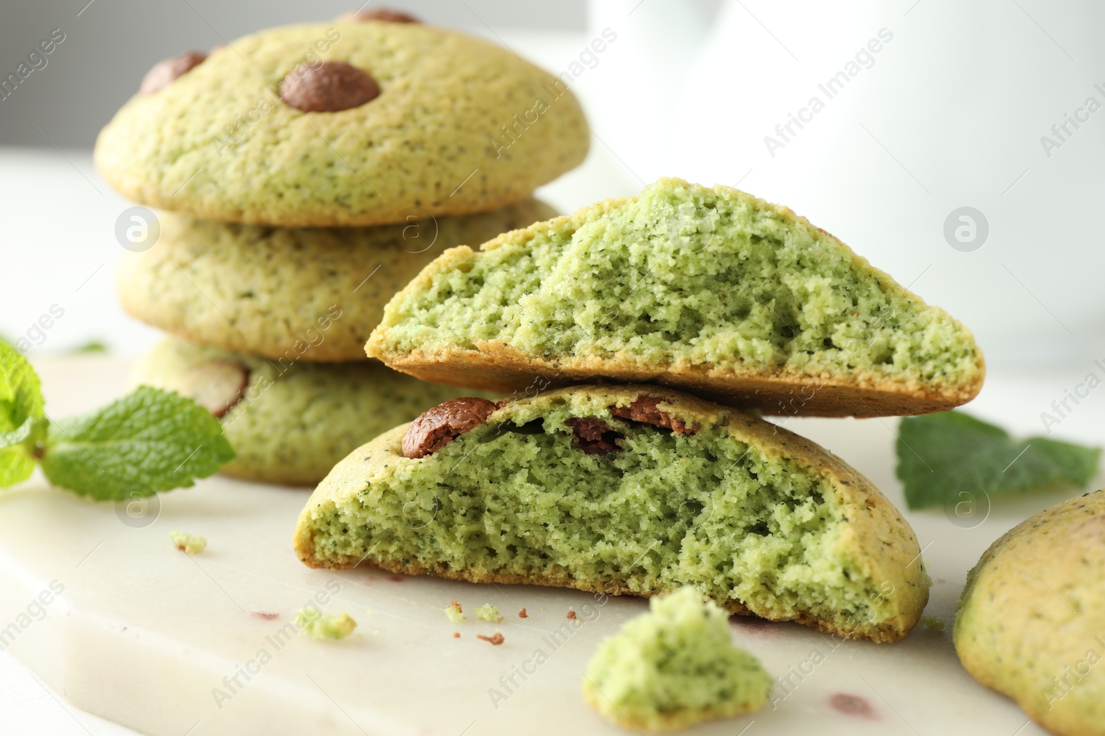 Photo of Delicious mint chocolate chip cookies on white table, closeup