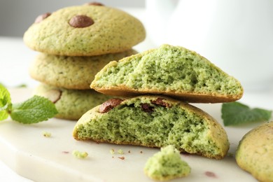 Photo of Delicious mint chocolate chip cookies on white table, closeup