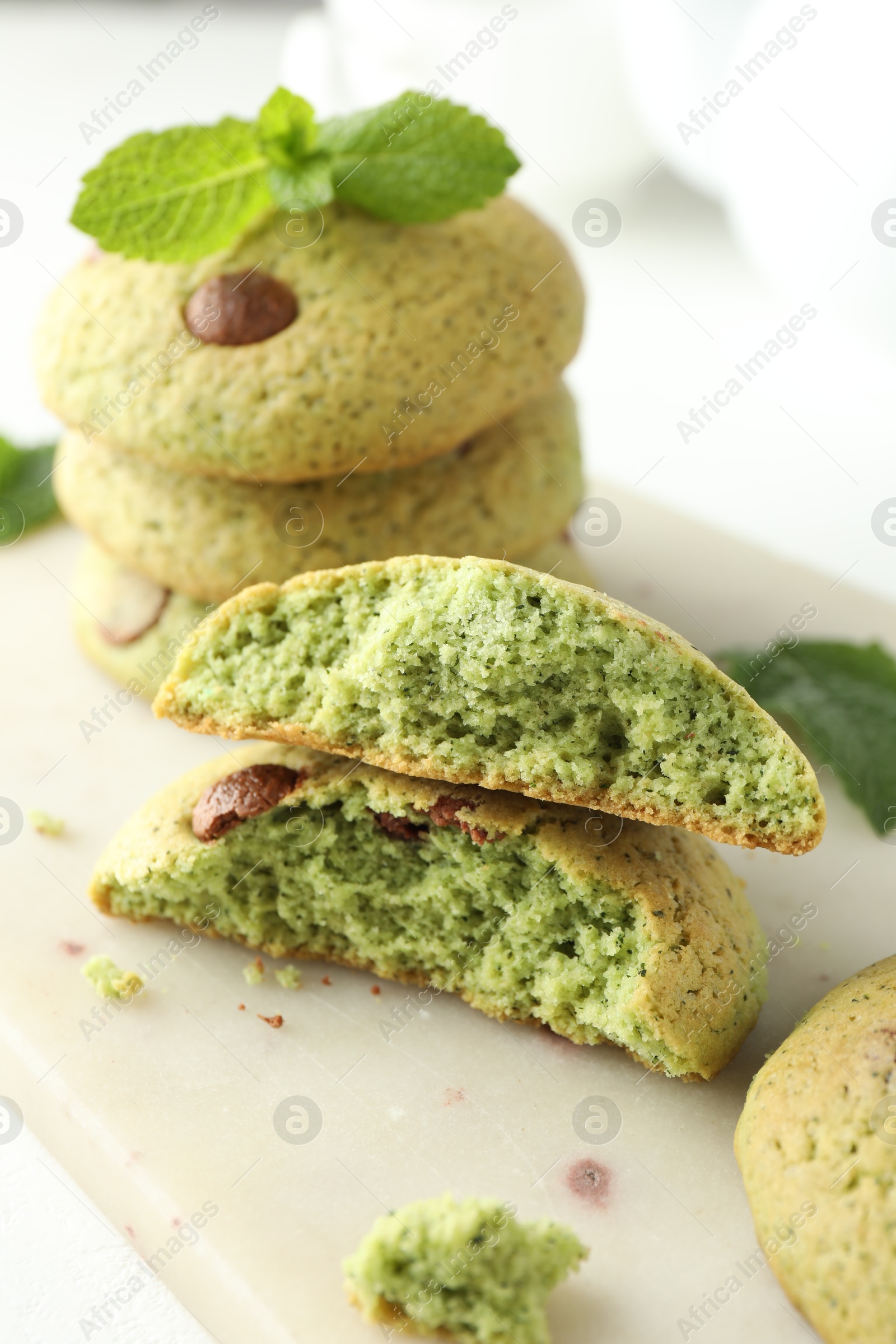 Photo of Delicious mint chocolate chip cookies on white table, closeup