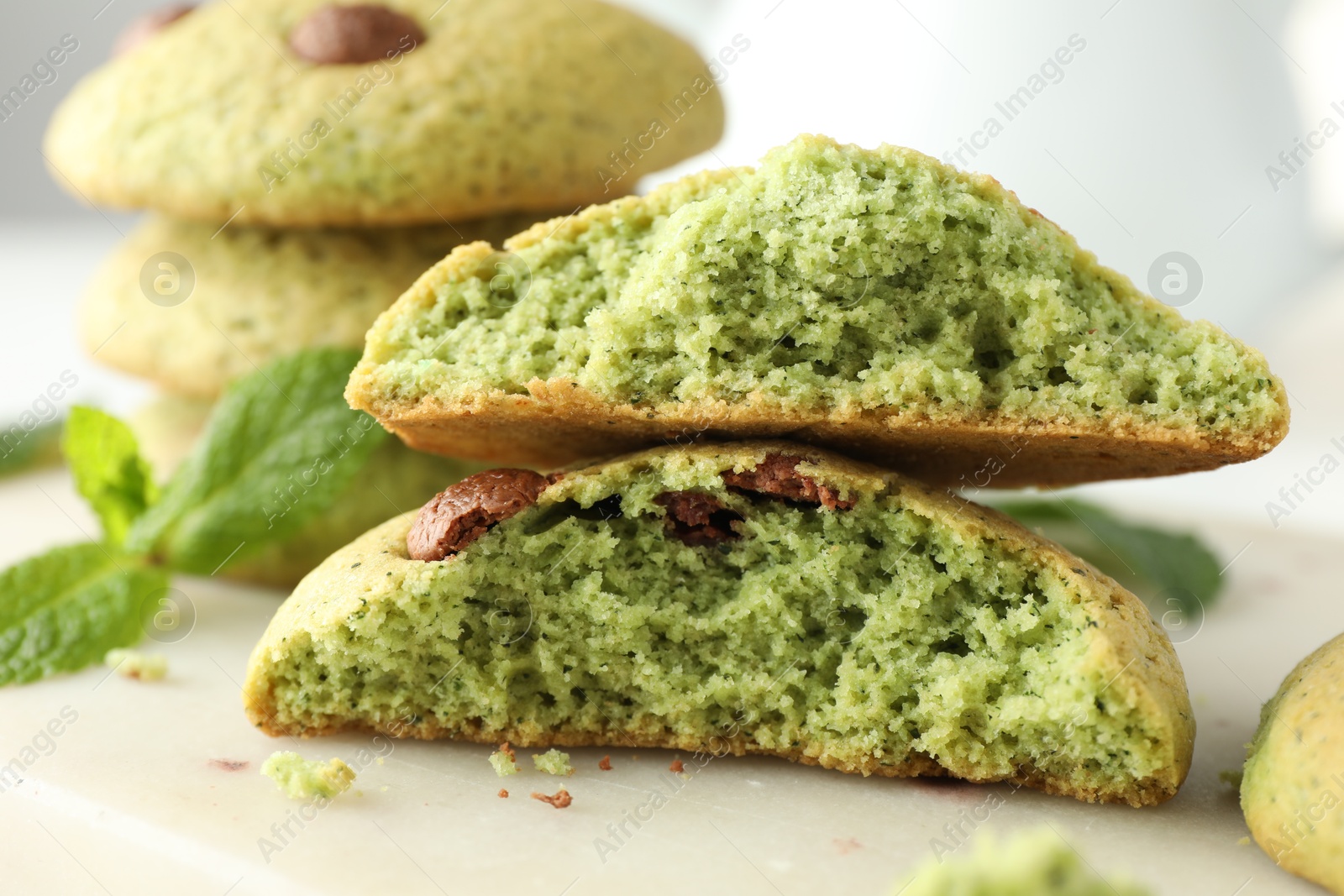 Photo of Delicious mint chocolate chip cookies on white table, closeup