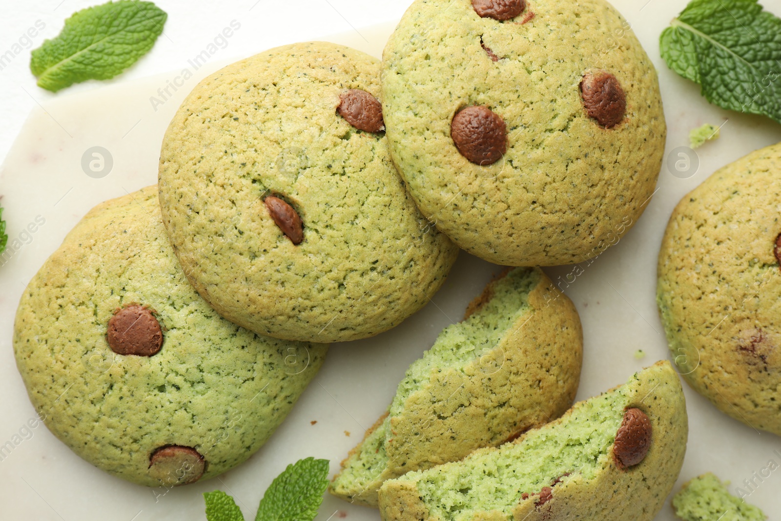 Photo of Delicious mint chocolate chip cookies on white table, flat lay