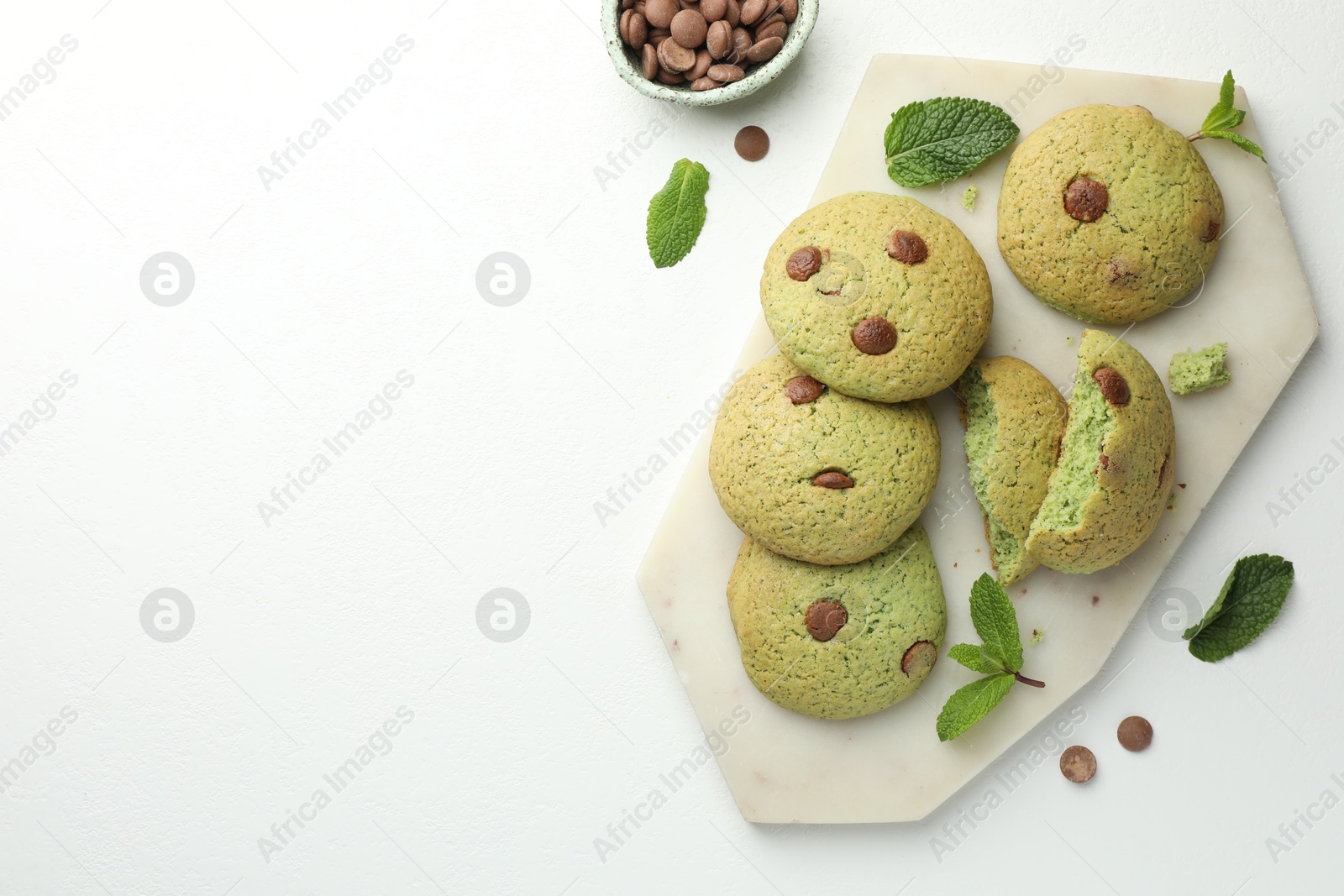 Photo of Delicious mint chocolate chip cookies on white table, flat lay. Space for text