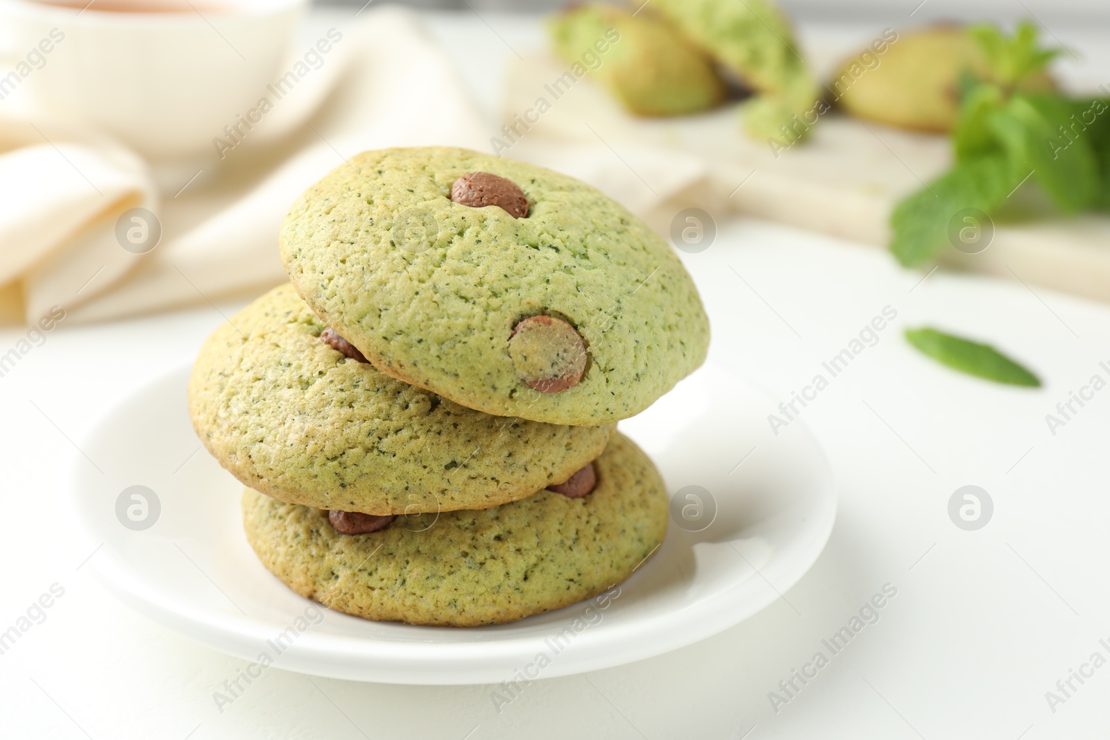 Photo of Delicious mint chocolate chip cookies on white table, closeup