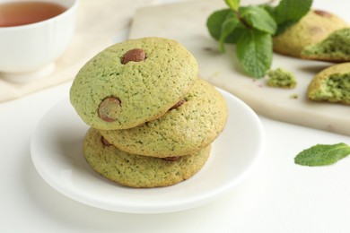 Photo of Delicious mint chocolate chip cookies on white table, closeup