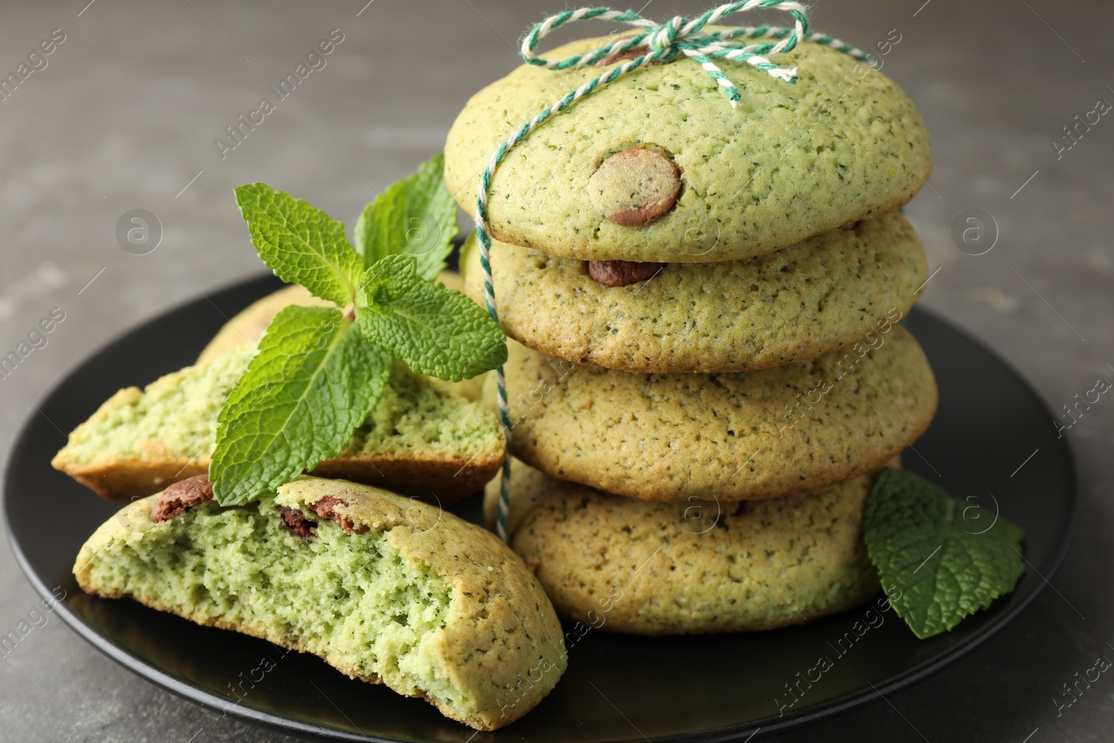 Photo of Delicious mint chocolate chip cookies on grey table, closeup