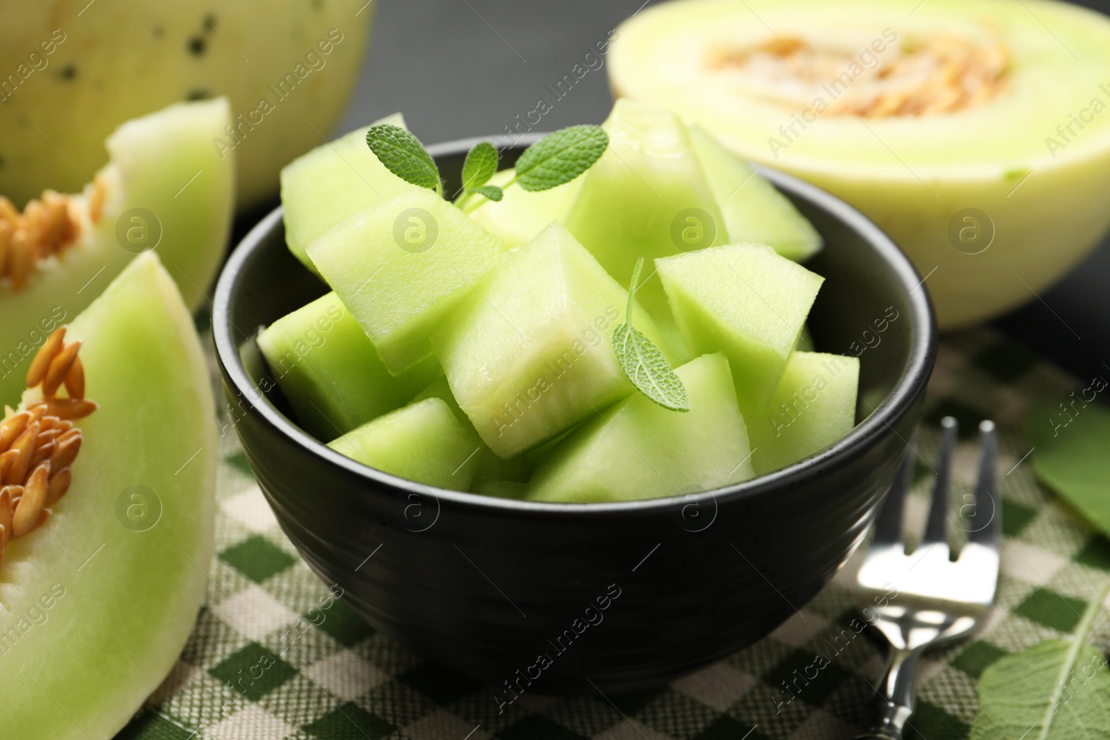 Photo of Slices of yummy melon on dark table, closeup