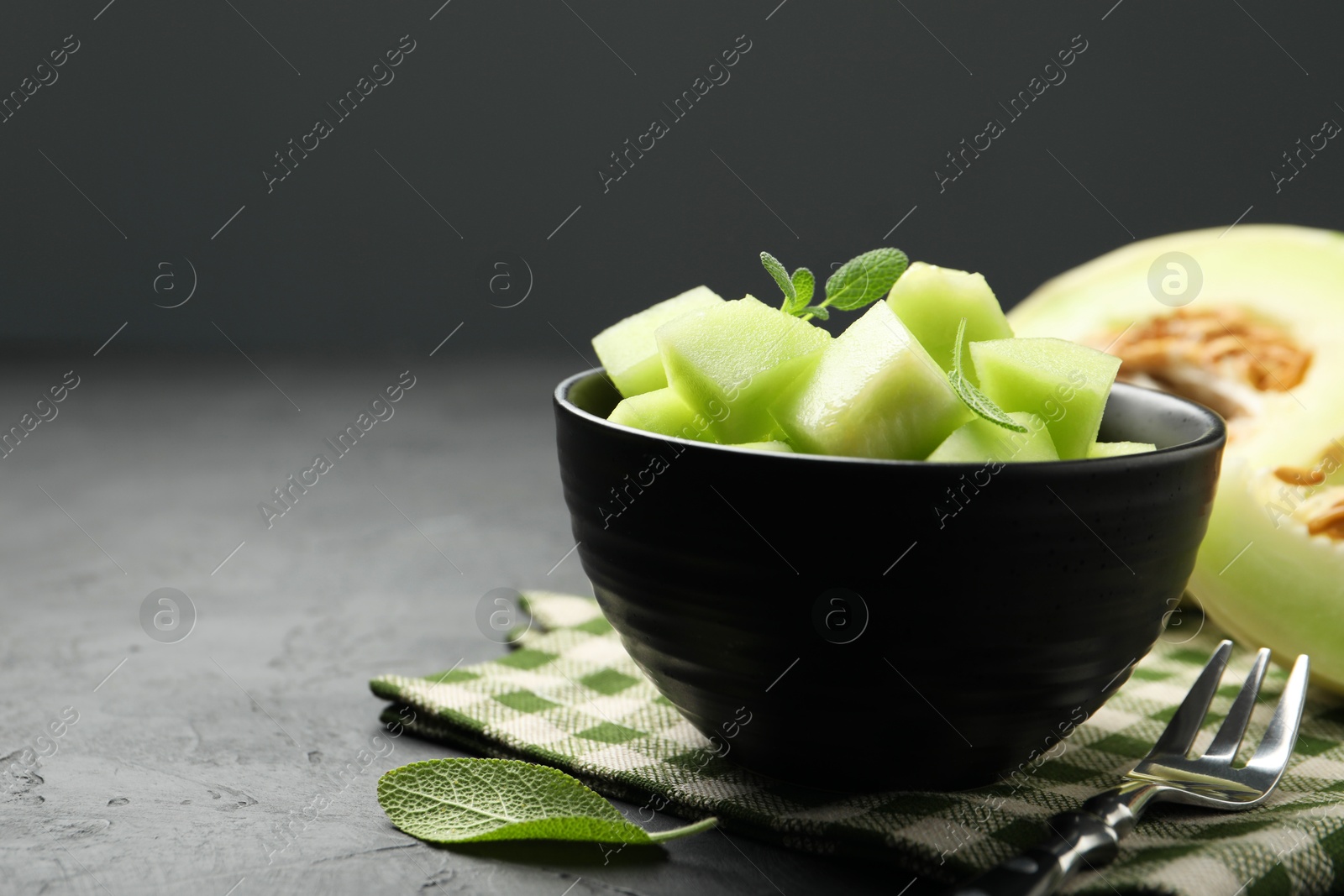 Photo of Slices of yummy melon on dark table, closeup. Space for text