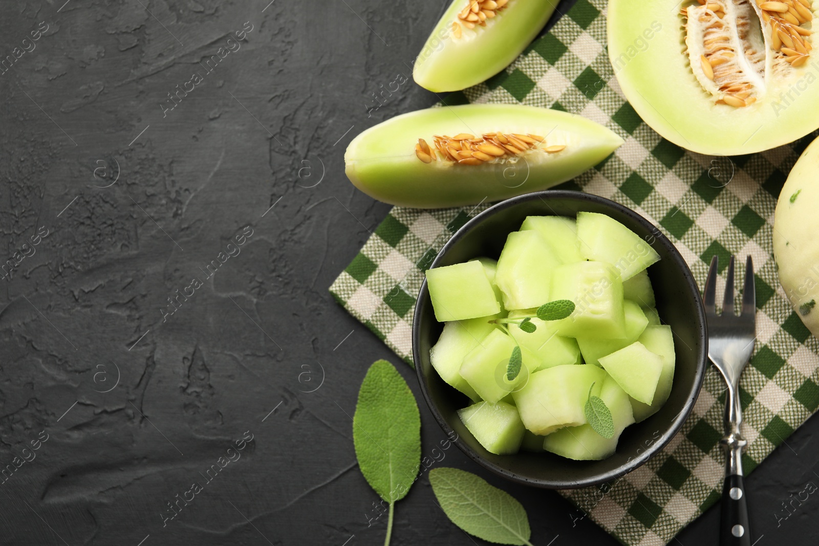 Photo of Slices of yummy melon on dark table, flat lay. Space for text