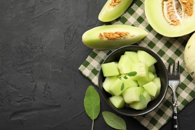 Photo of Slices of yummy melon on dark table, flat lay. Space for text