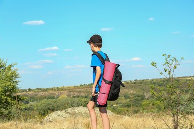 Photo of Little boy with backpack travelling outdoors on sunny day