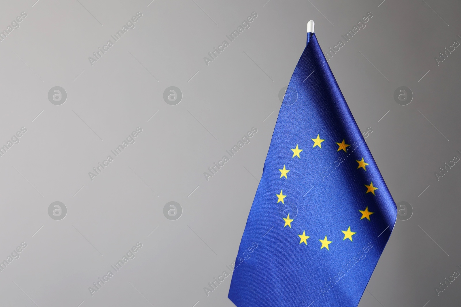 Photo of One flag of European Union on grey background. Space for text