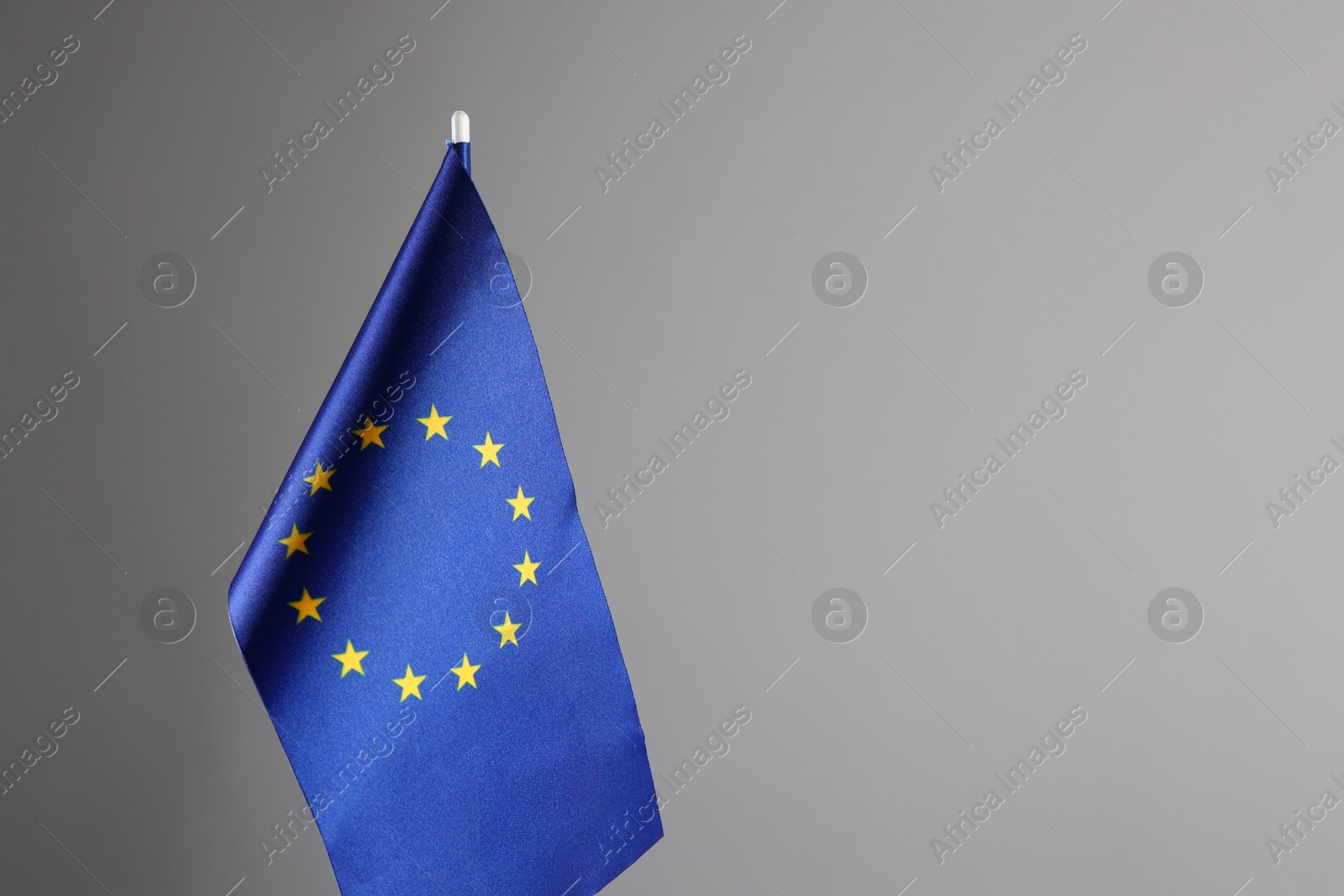 Photo of One flag of European Union on grey background. Space for text