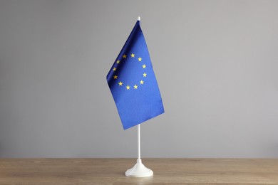 One flag of European Union on wooden table against grey background