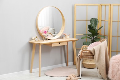 Photo of Mirror, dressing table, houseplant, folding screen and chair indoors. Interior design