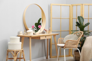 Photo of Mirror, dressing table, houseplant, folding screen and chair indoors. Interior design