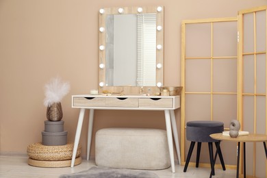 Photo of Stylish dressing table with mirror in room