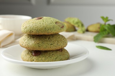 Photo of Delicious mint chocolate chip cookies on white table, closeup