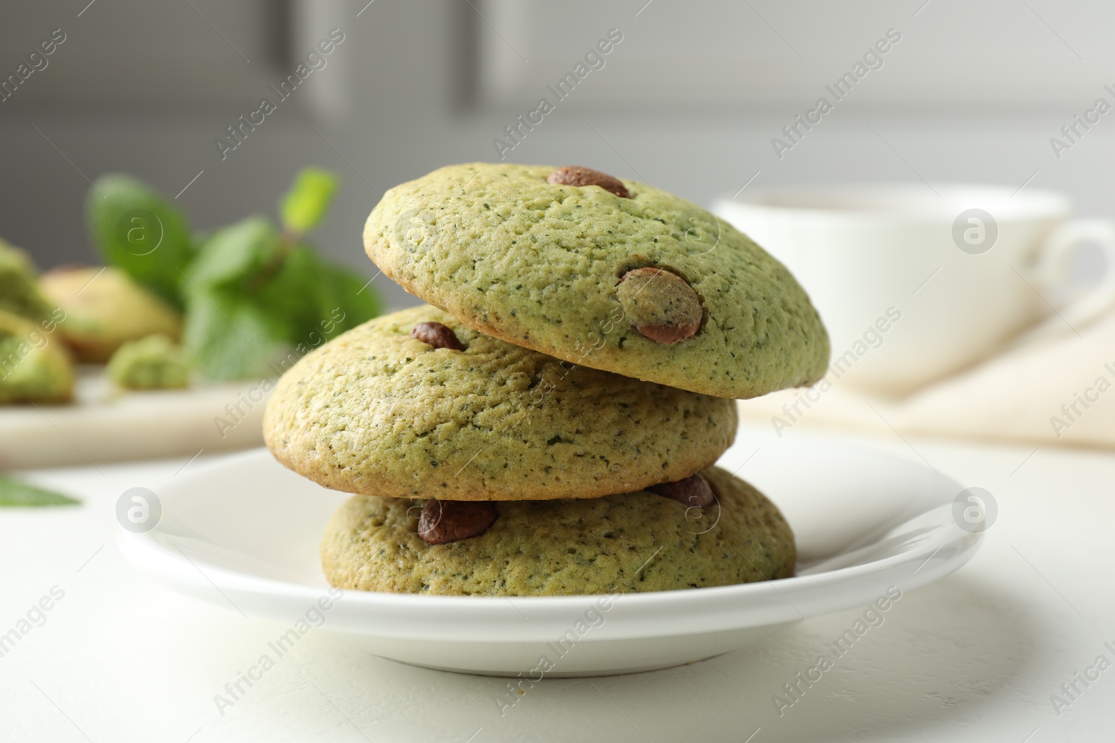 Photo of Delicious mint chocolate chip cookies on white table, closeup