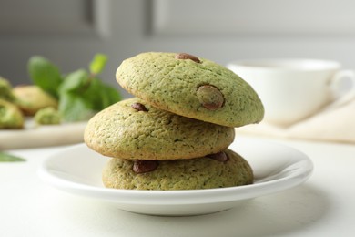 Photo of Delicious mint chocolate chip cookies on white table, closeup